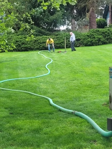 Bob's Septic Service technician inspecting a residential septic system in a Clark County yard.